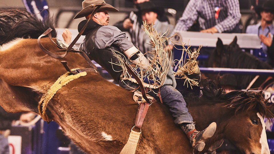 Orin Larsen staring intently while standing in the rodeo arena.