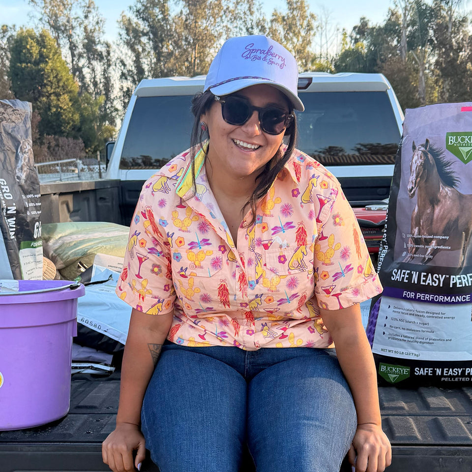 Michelle Serna, on a truck bed with horse feed in the back.