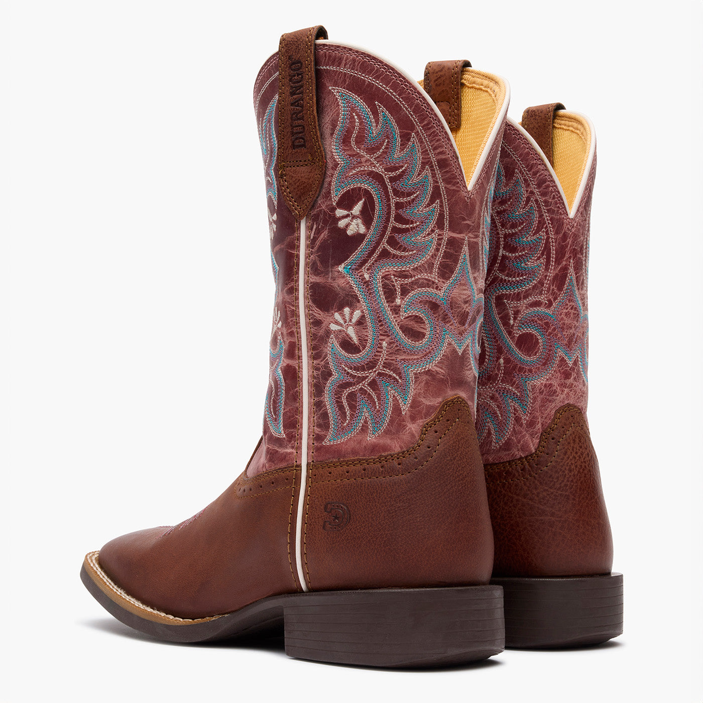 Brown cowboy boots with intricate embroidery on a white background