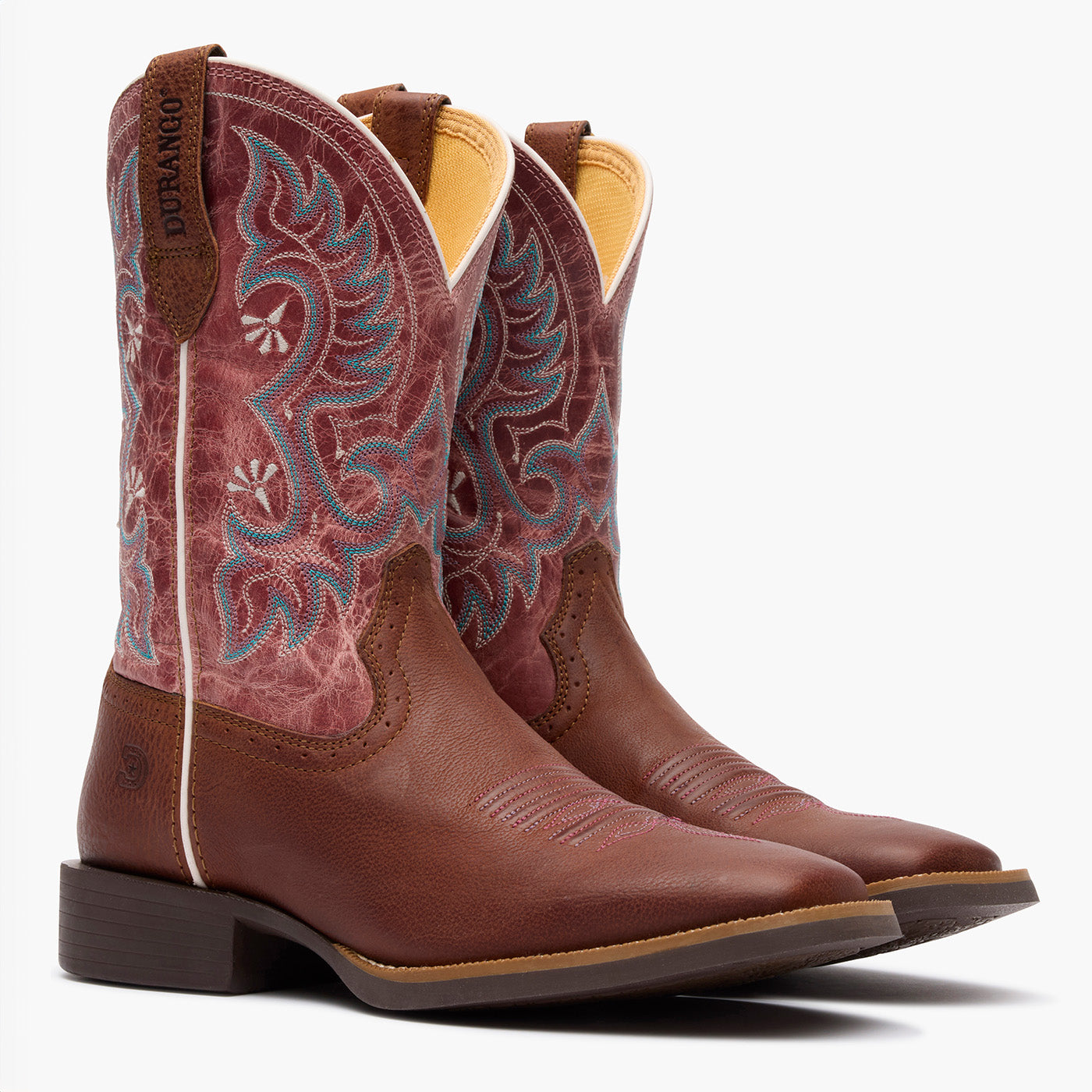 Brown cowboy boots with intricate stitching on a white background