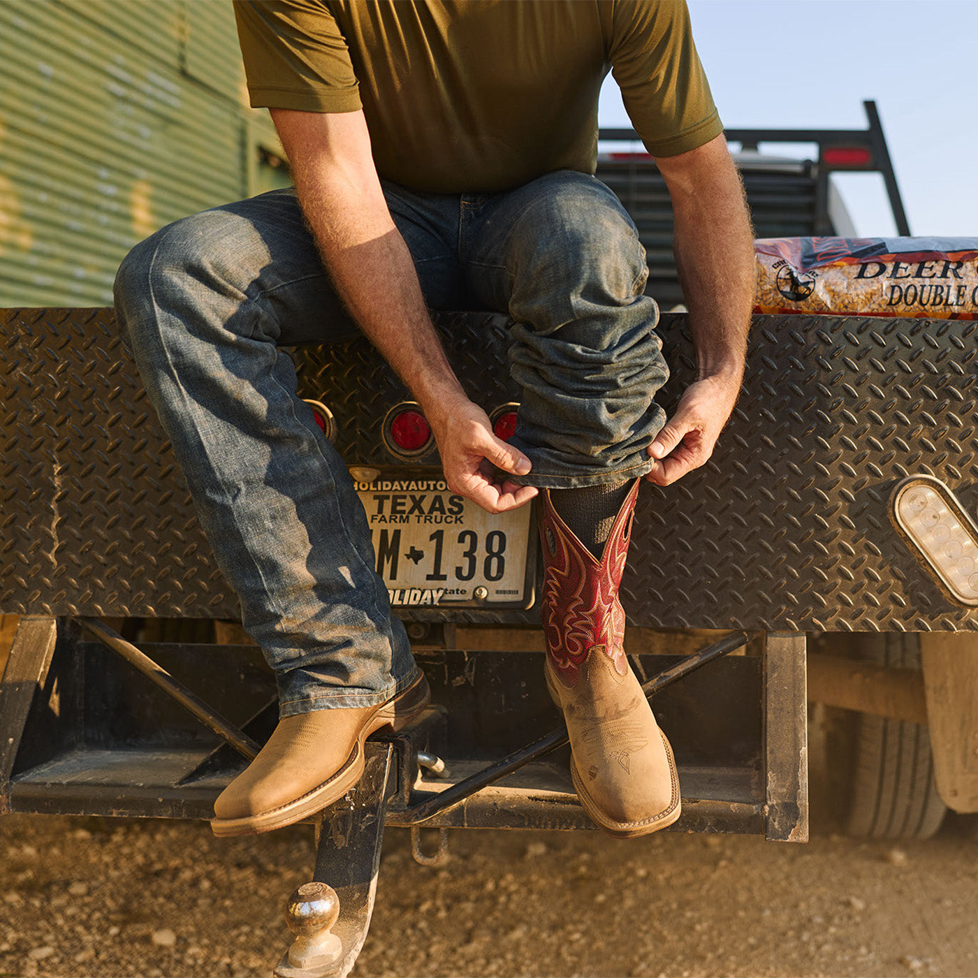 Man wearing Durango Rebel Ultra Lite western boots sitting on a truck bed with Texas license plate.