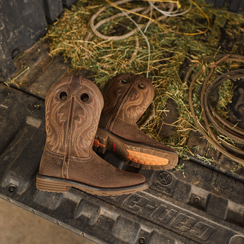 Brown Durango work boots on a UTV bed with grass and rope in the background