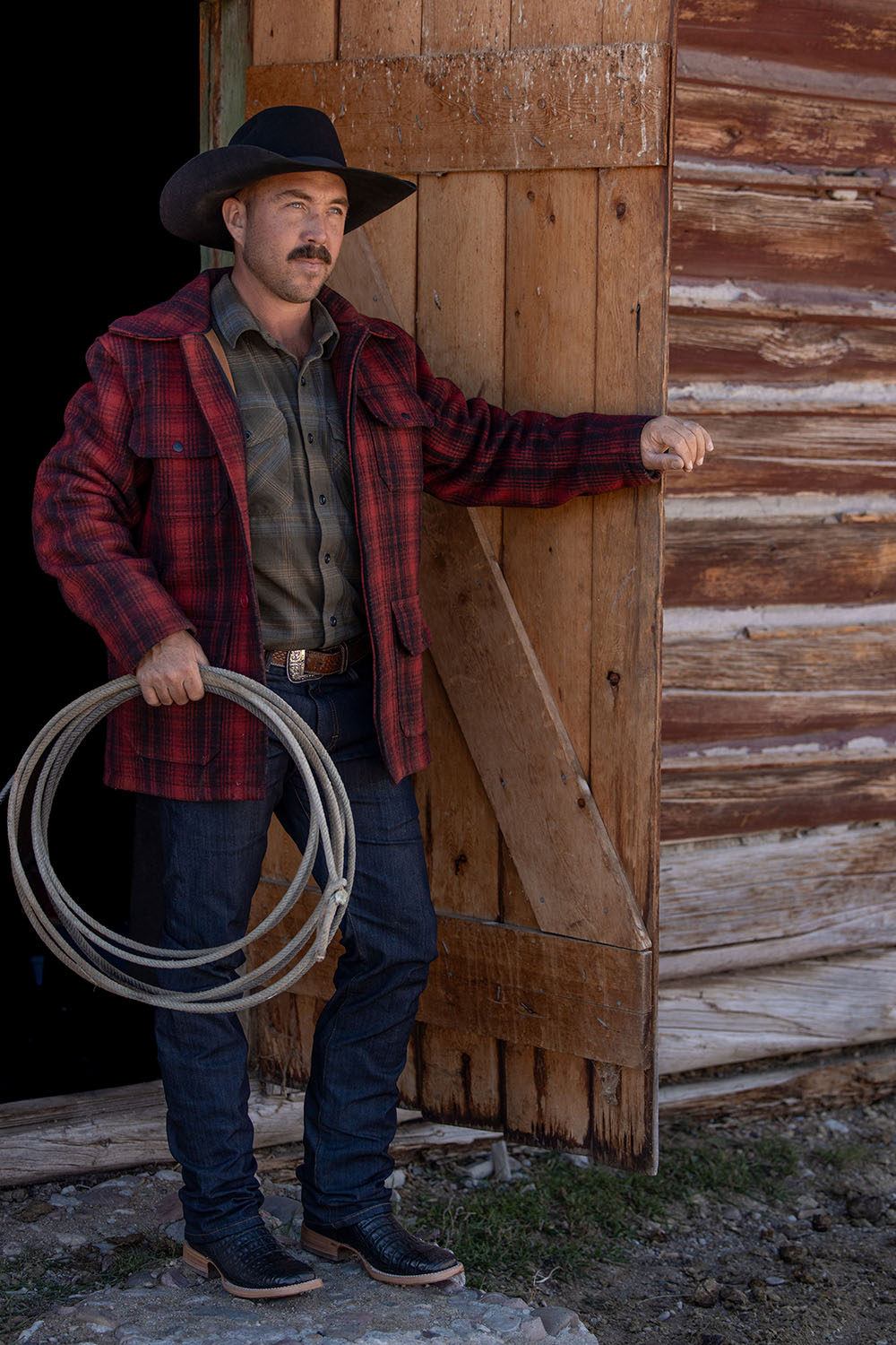 Cowboy standing at barn door